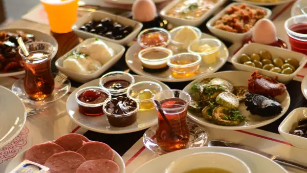Antikköy'ün zengin açık büfe kahvaltı sofrası: reçeller, zeytin çeşitleri, peynirler, kahvaltılıklar ve Türk çayı bir arada.